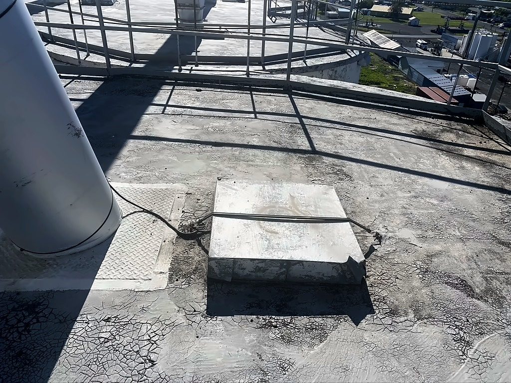 Before: CHS grain silo roof in Grangeville, Idaho, with stains and old patches on the concrete