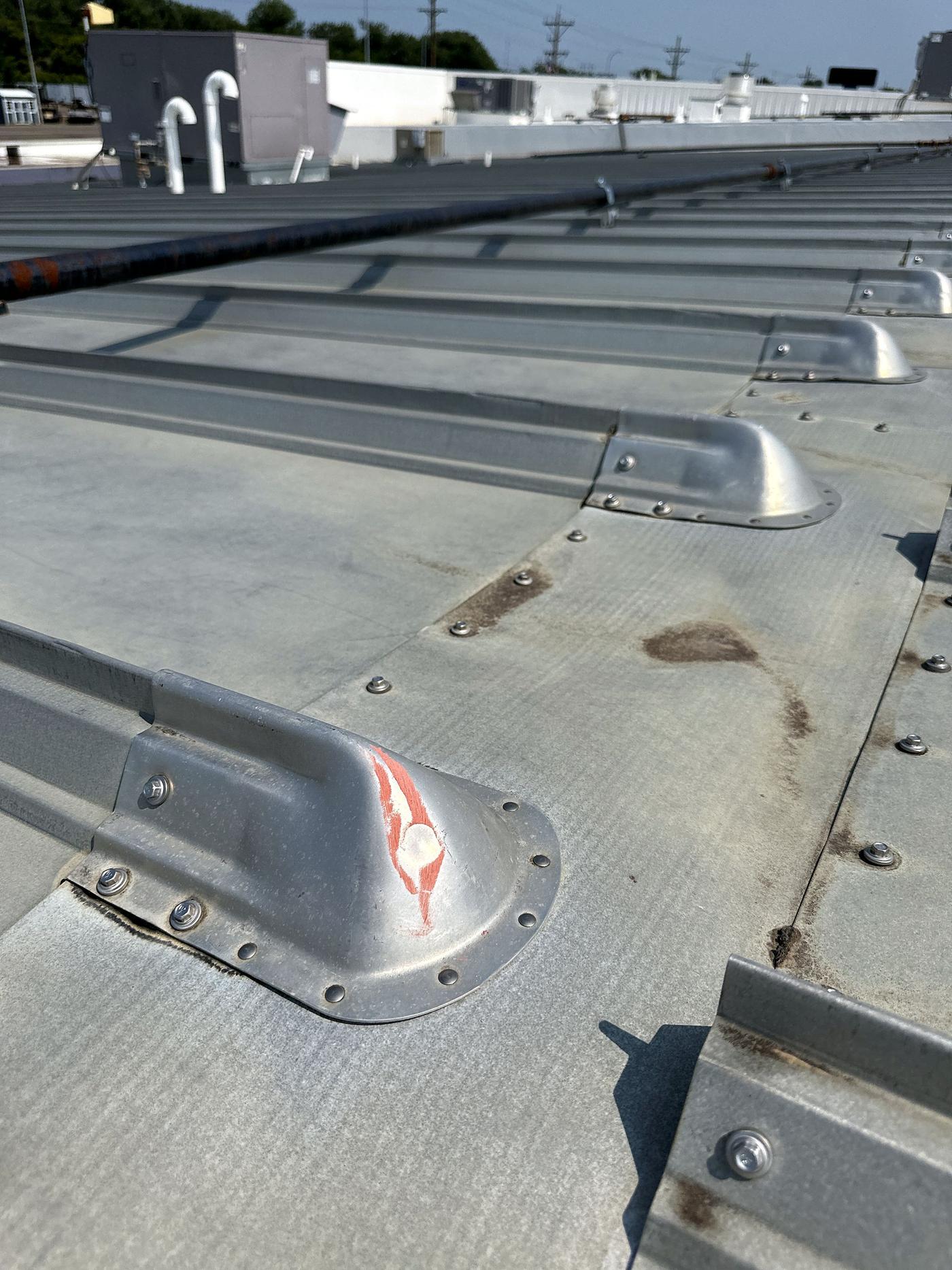 Metal roof section with curbs, chalk-marked during inspection (Jul 2023)